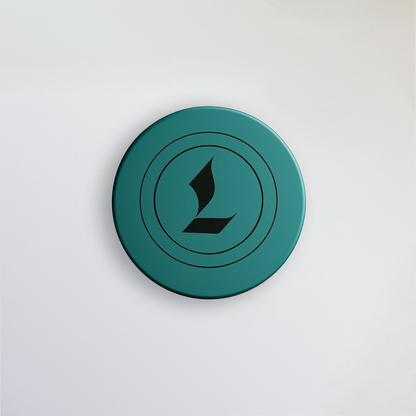 Aerial image of Louviere Lip Dew. Signature color is eagle green. Louviere's L shaped logo is imprinted on the top of the cap.